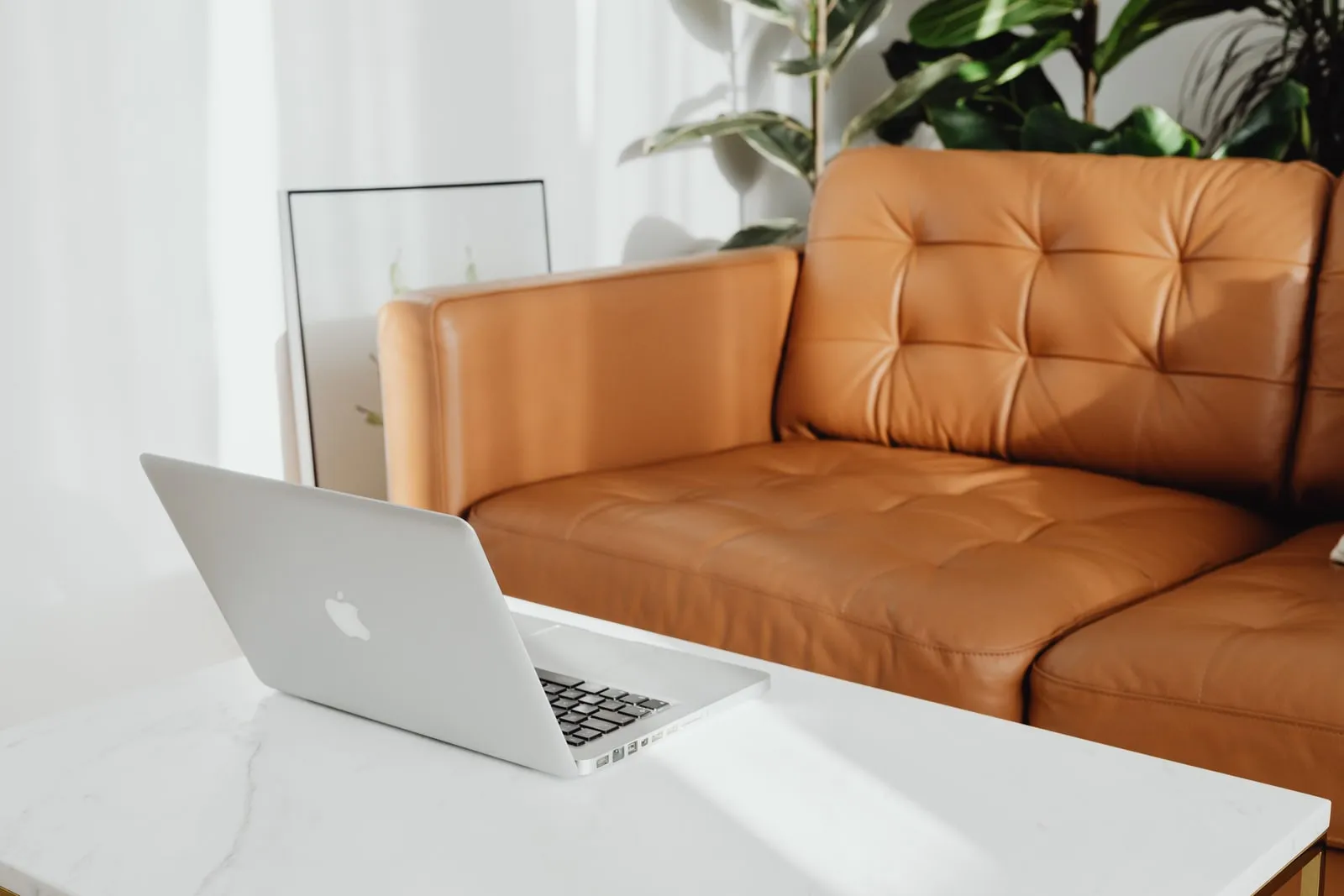 A laptop open on a table in a living room