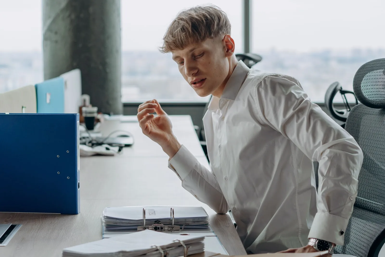 An office worker reading printed documents at a desk