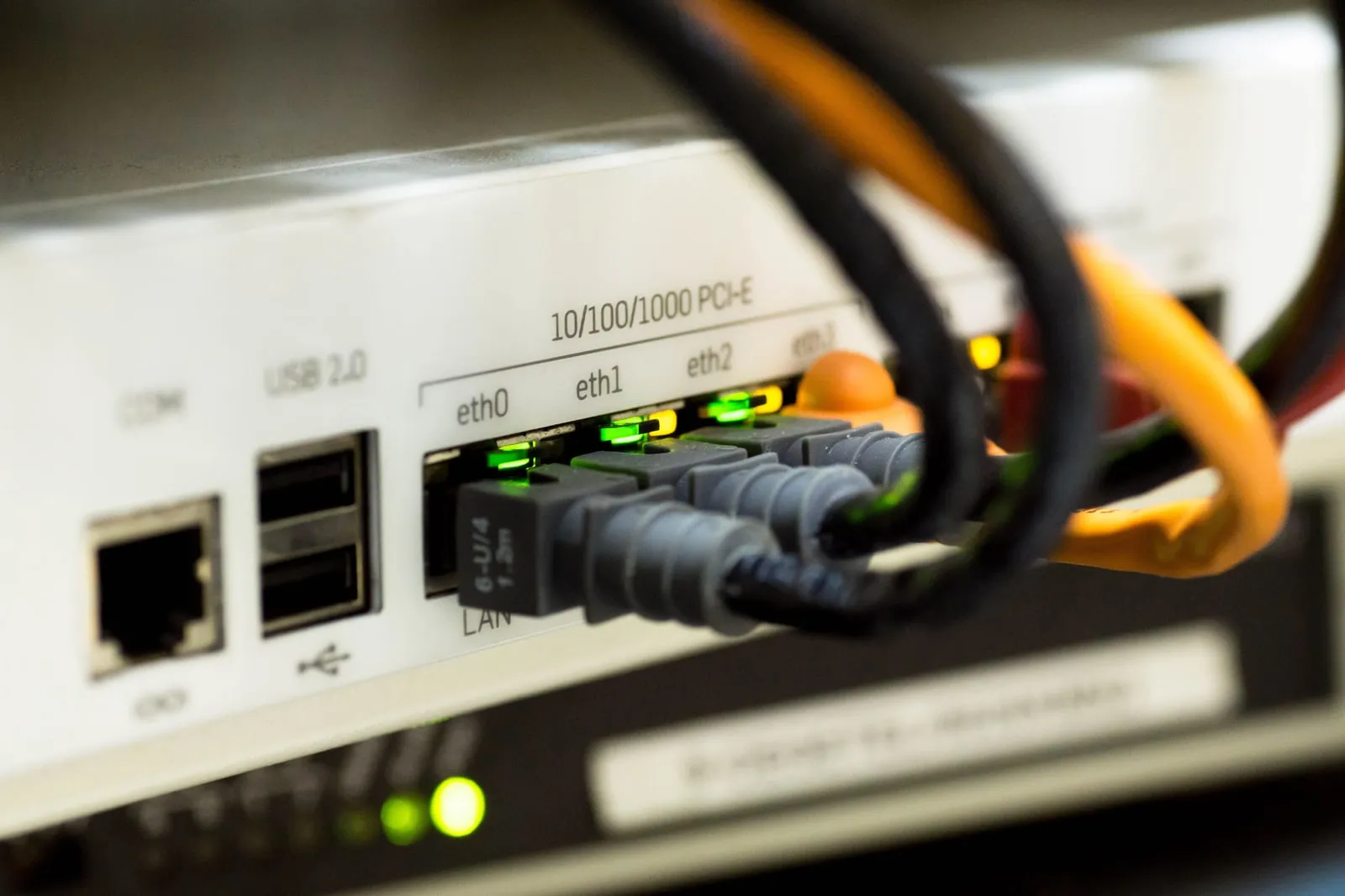 Network cables plugged into the ethernet ports of a rack-mounted device