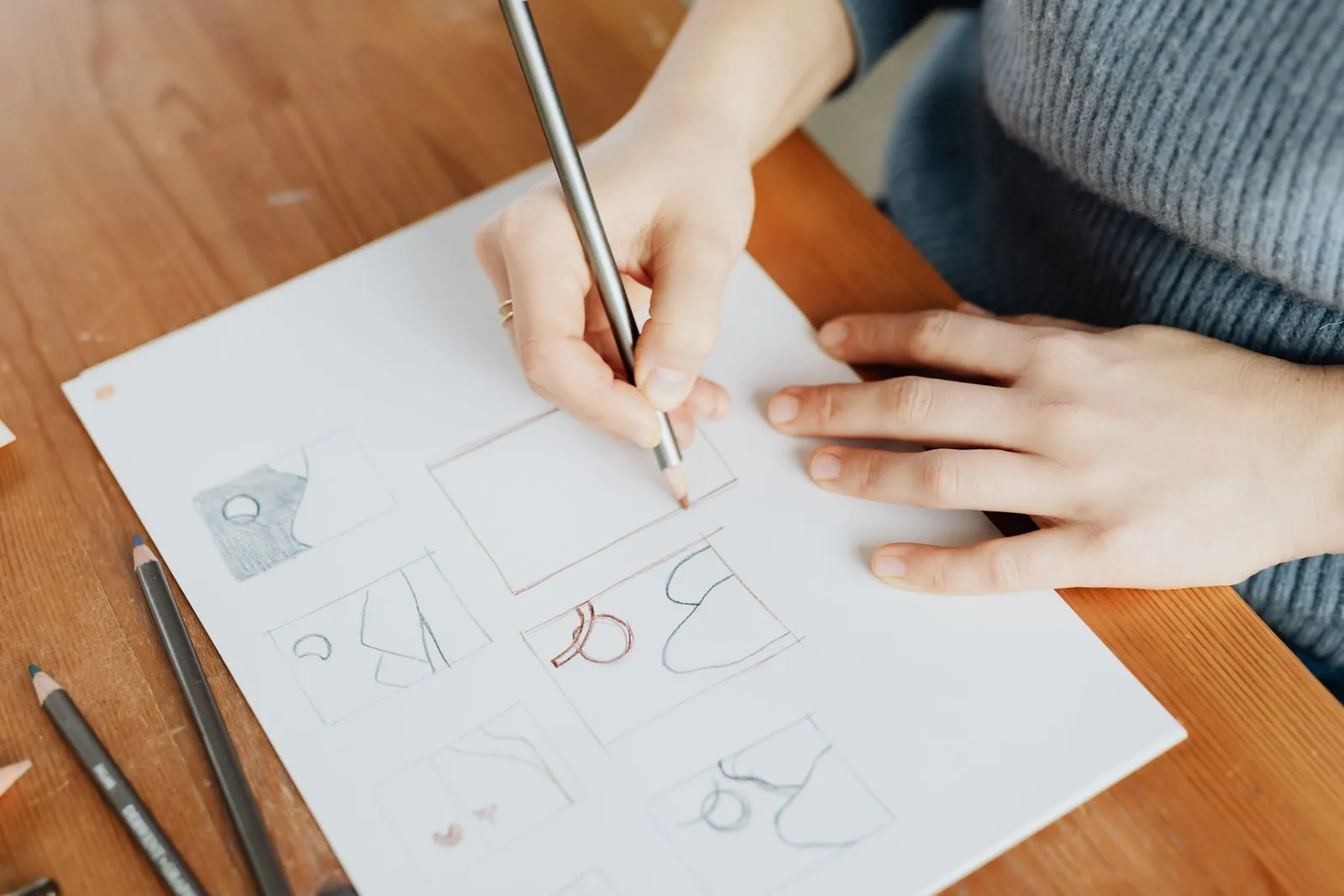 A designer sketching on paper at a desk