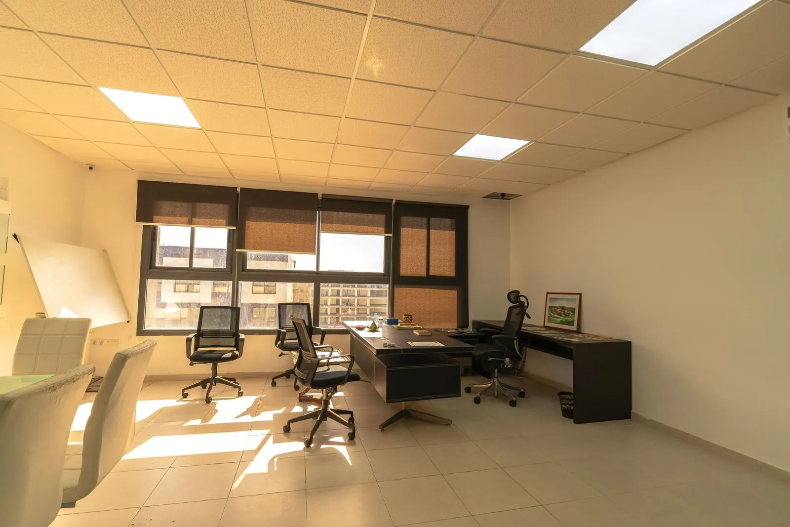 Sunlight falling across an empty office with desks and chairs