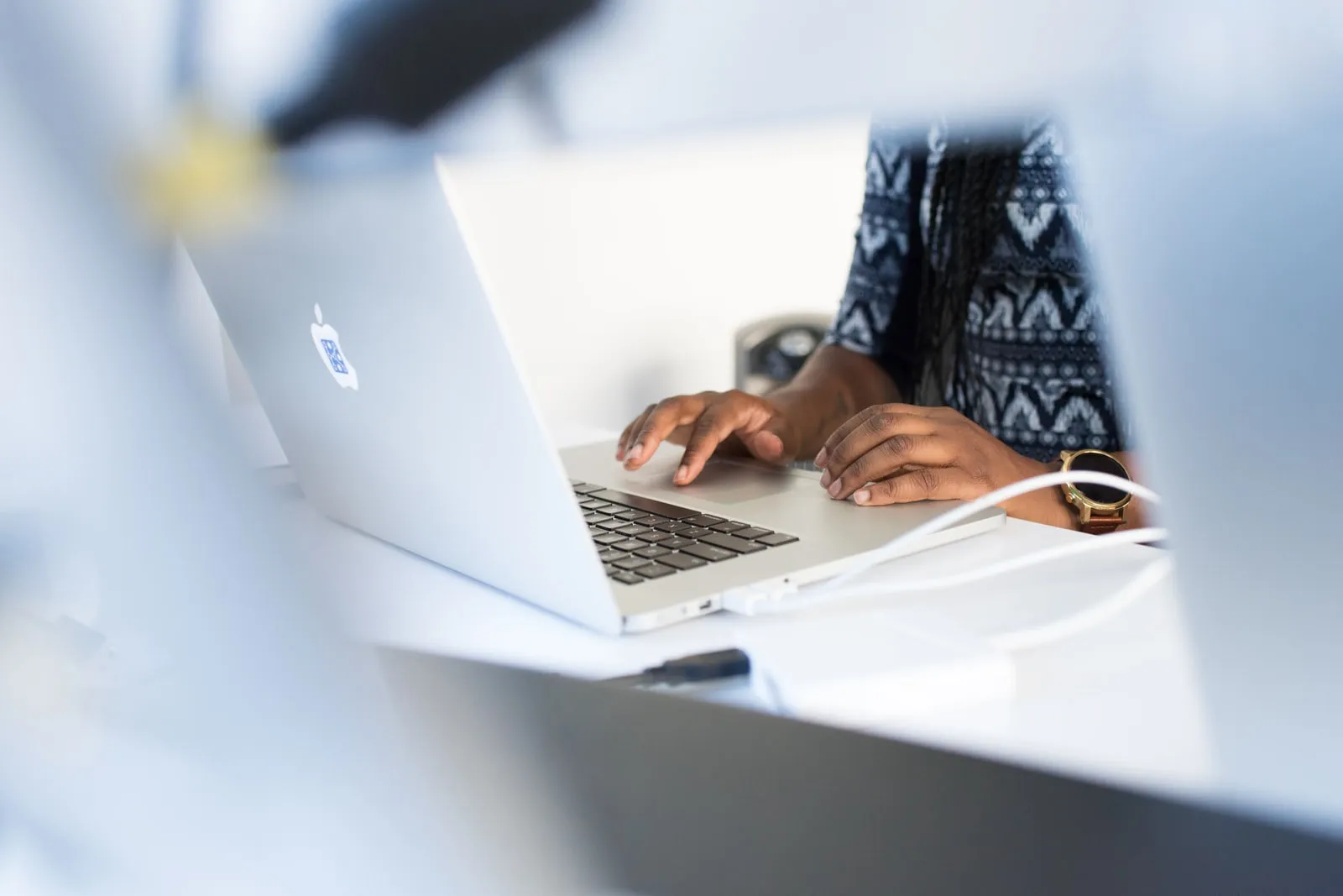 A person working at a laptop at an office desk