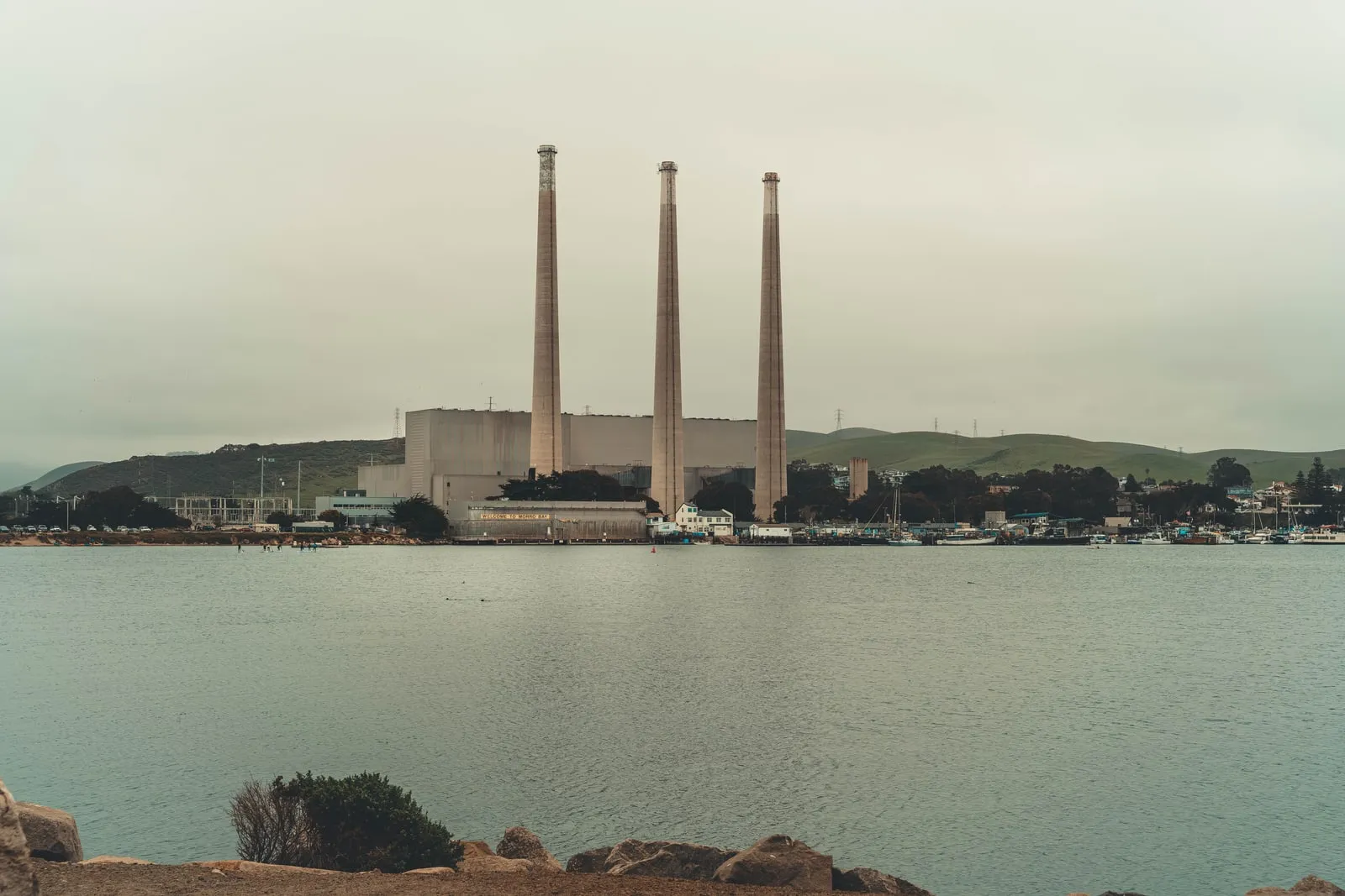 Industrielle kraftværksskorstene ved en kystlinje