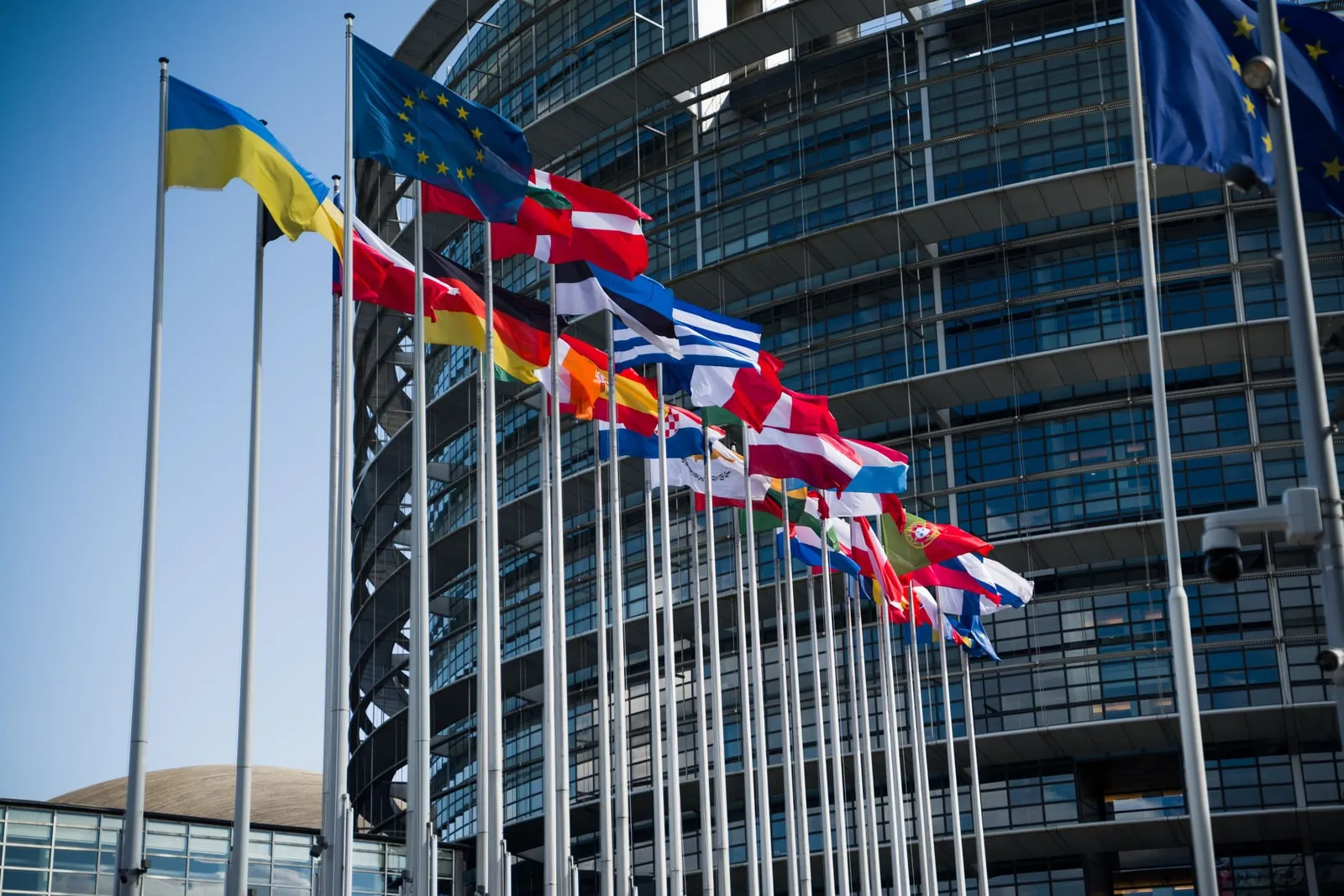 Flags on poles in front of a modern building