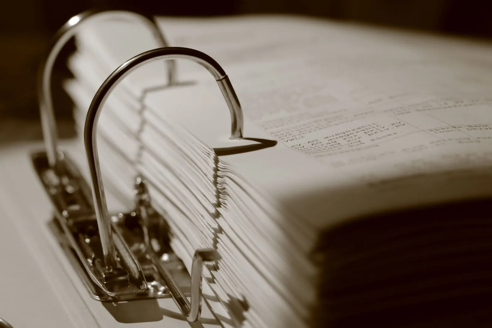 An open ring binder packed with printed documents