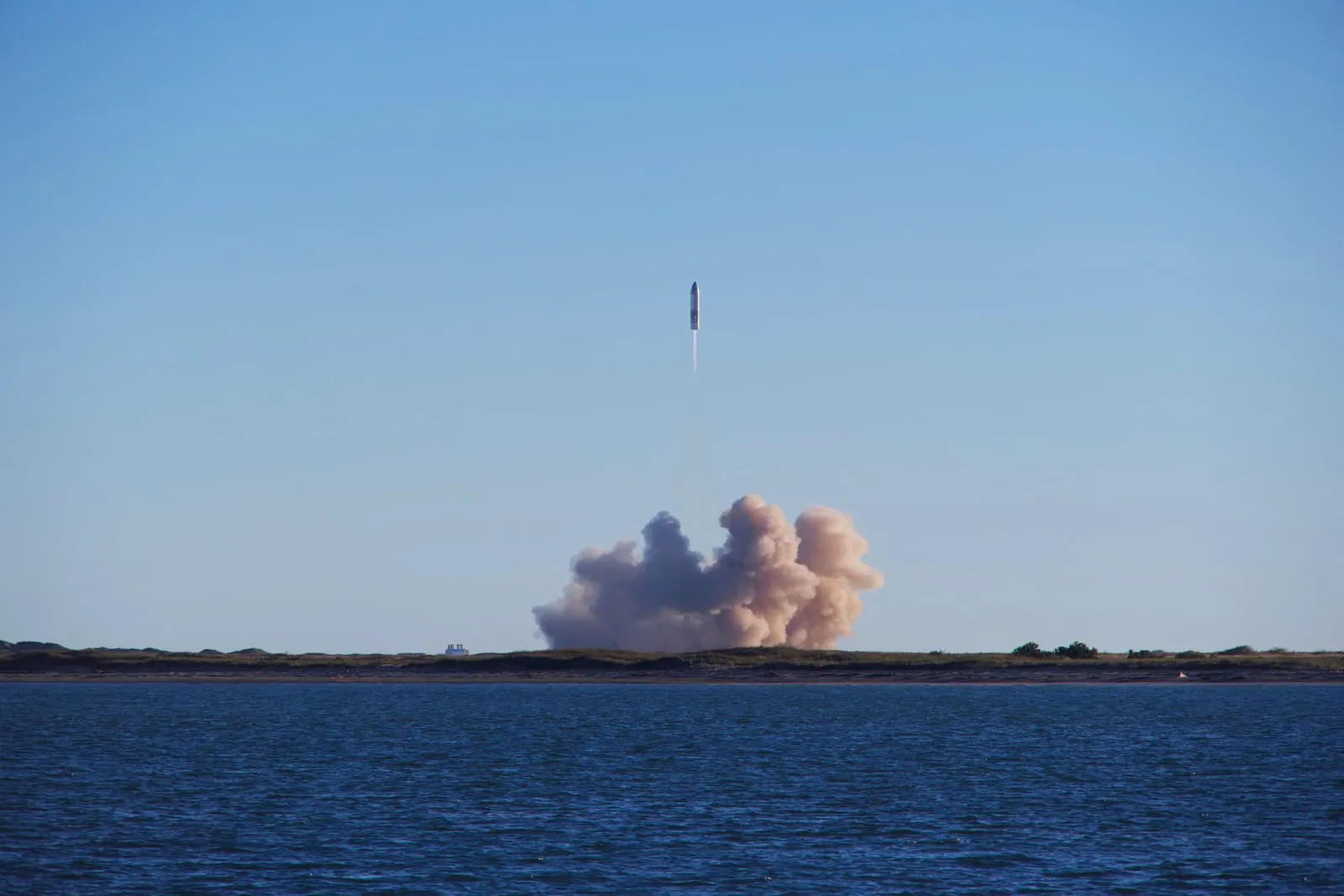 A rocket lifting off from a launch pad trailing exhaust