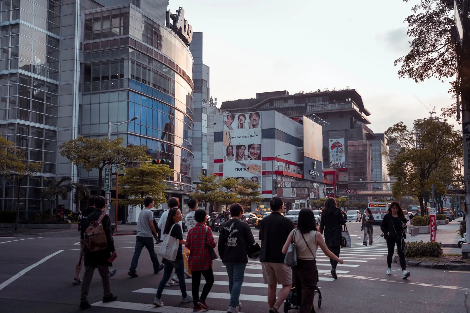 A busy pedestrian crossing in a city at dusk