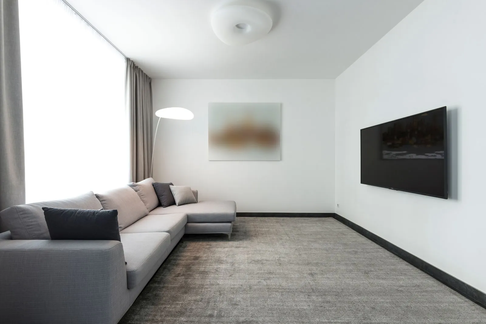 A living room with a sofa and a wall-mounted television