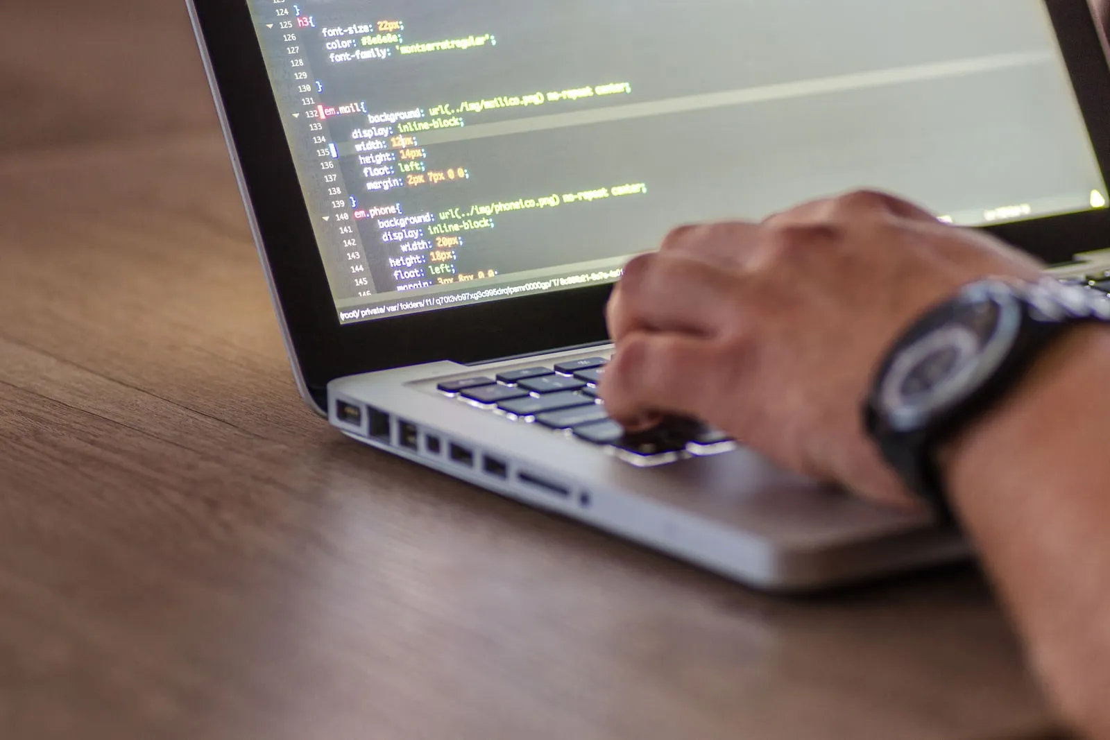 A developer typing code on a laptop