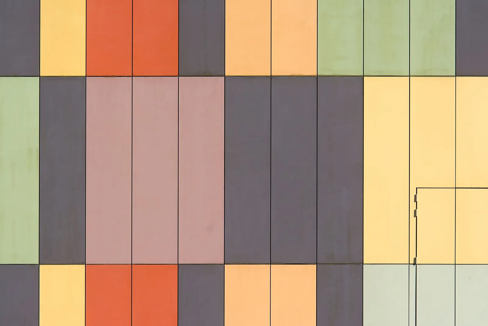 A building facade of coloured rectangular panels laid out in a grid