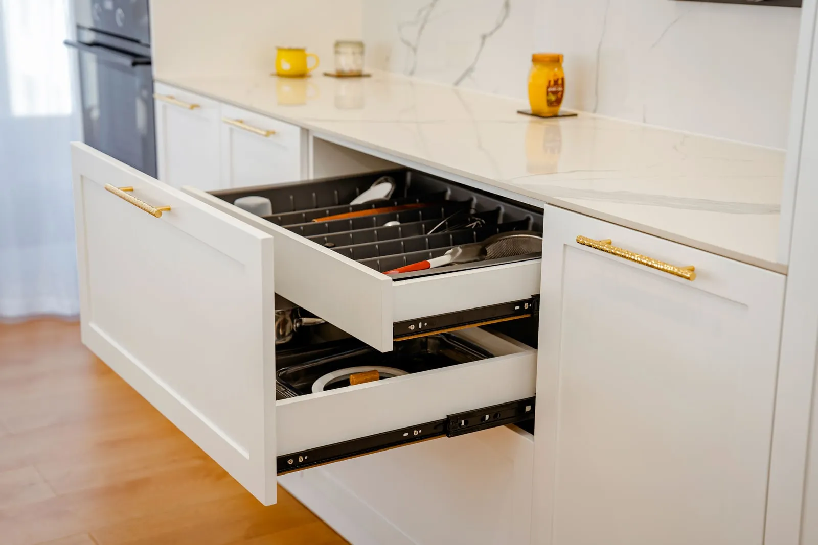 An open kitchen drawer with utensils inside