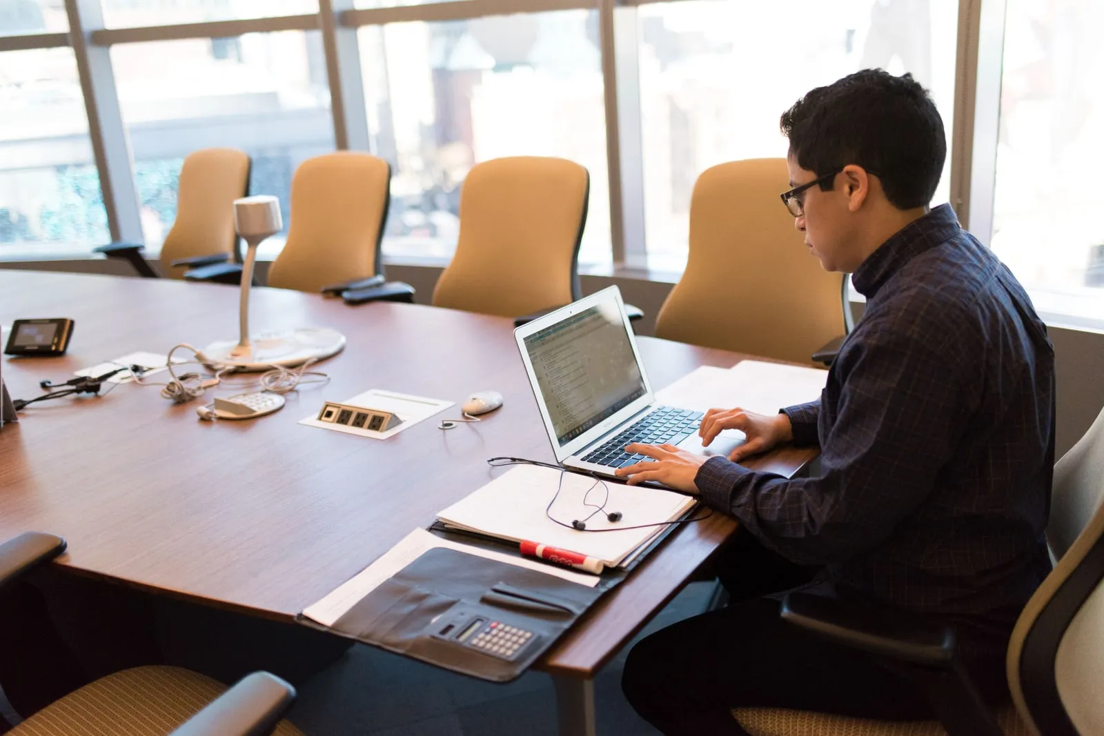A person typing on a laptop keyboard in an office