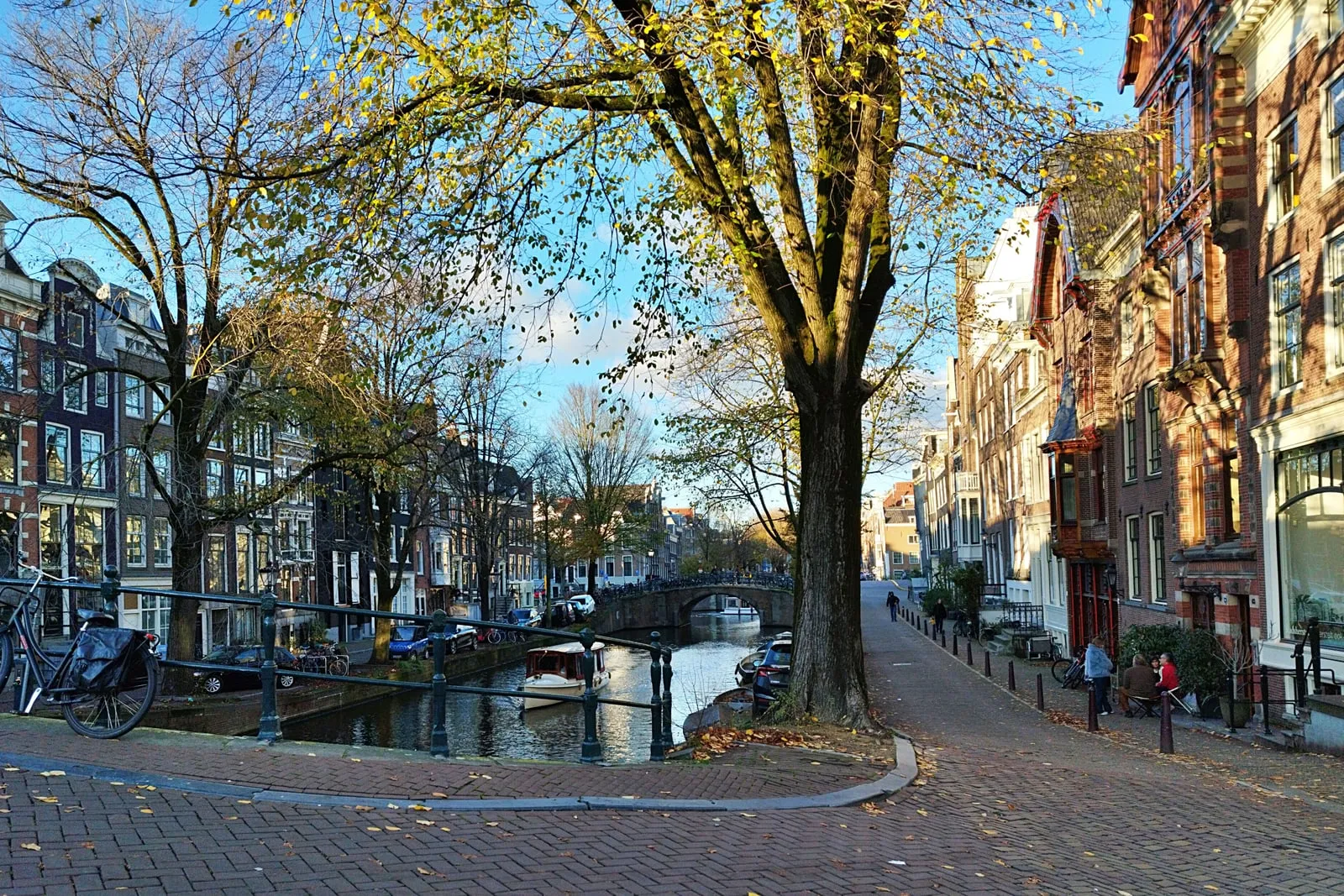 A city street in Amsterdam with a canal and bicycles