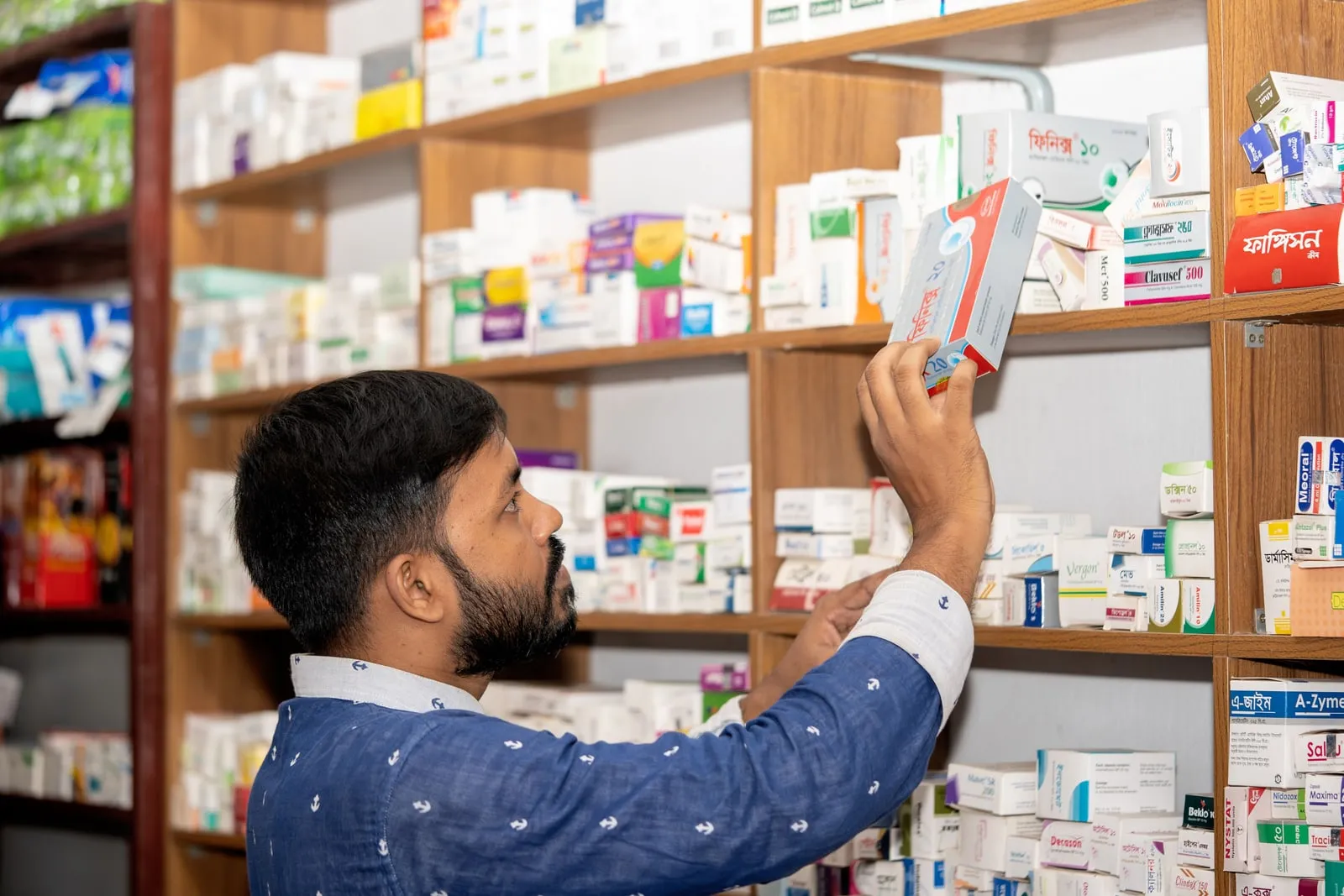 Pharmacy shelves stocked with medicine boxes