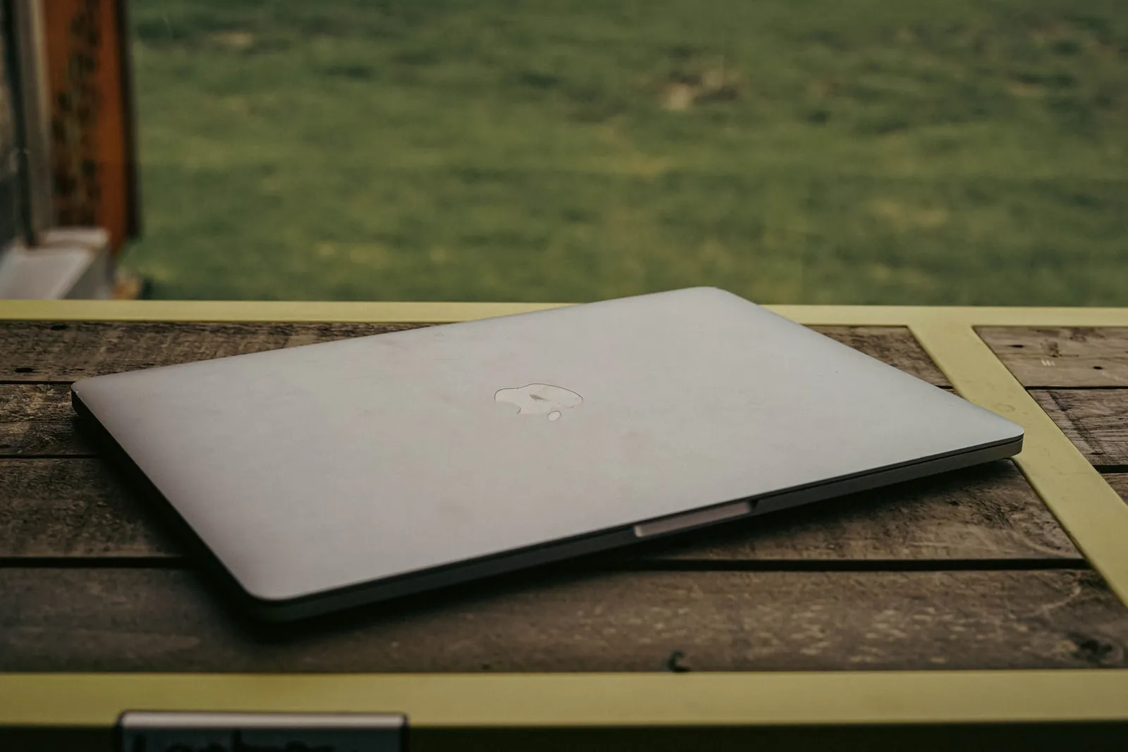 Laptops set up on a folding table outdoors in a field