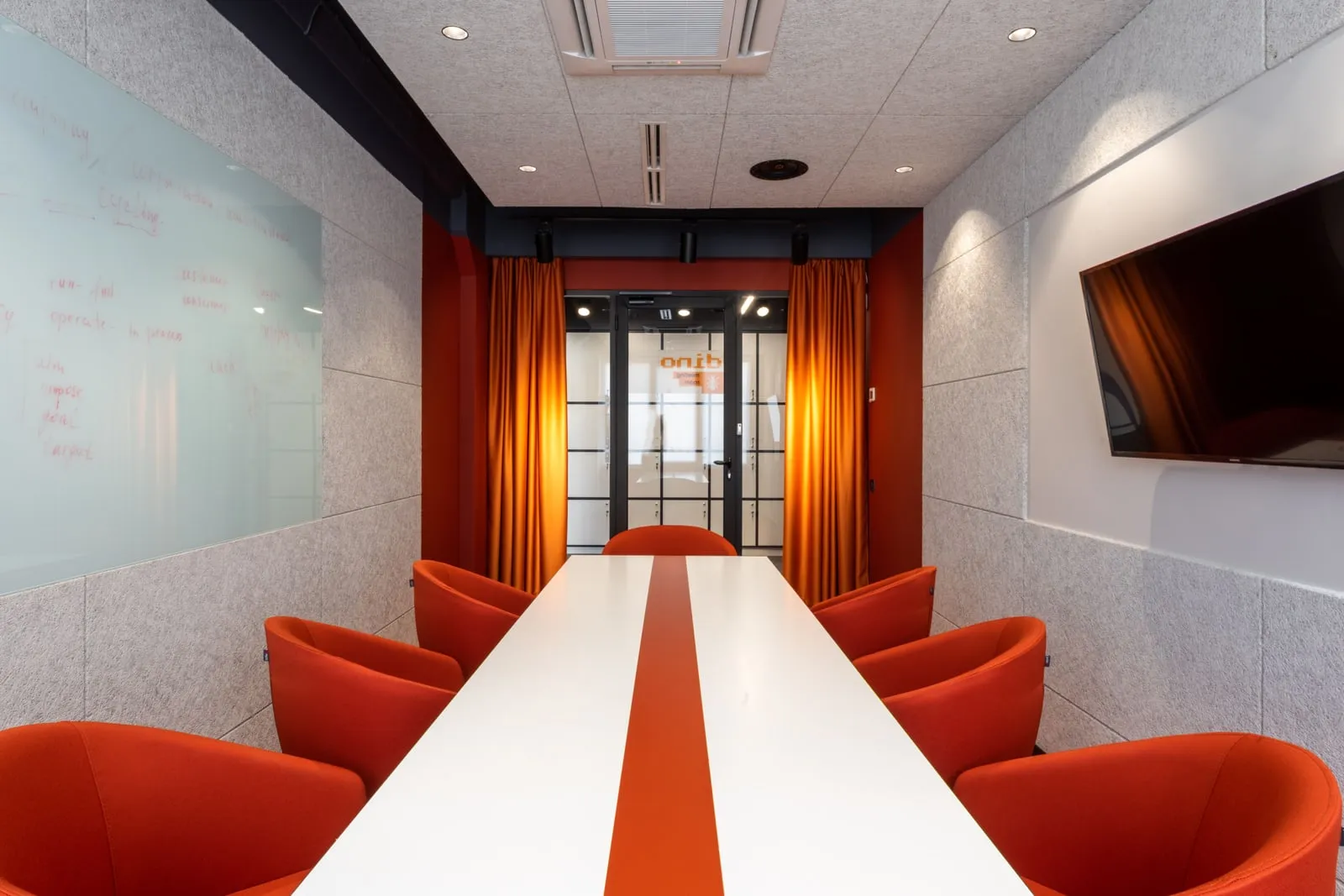 An empty office meeting room with a long table and a whiteboard