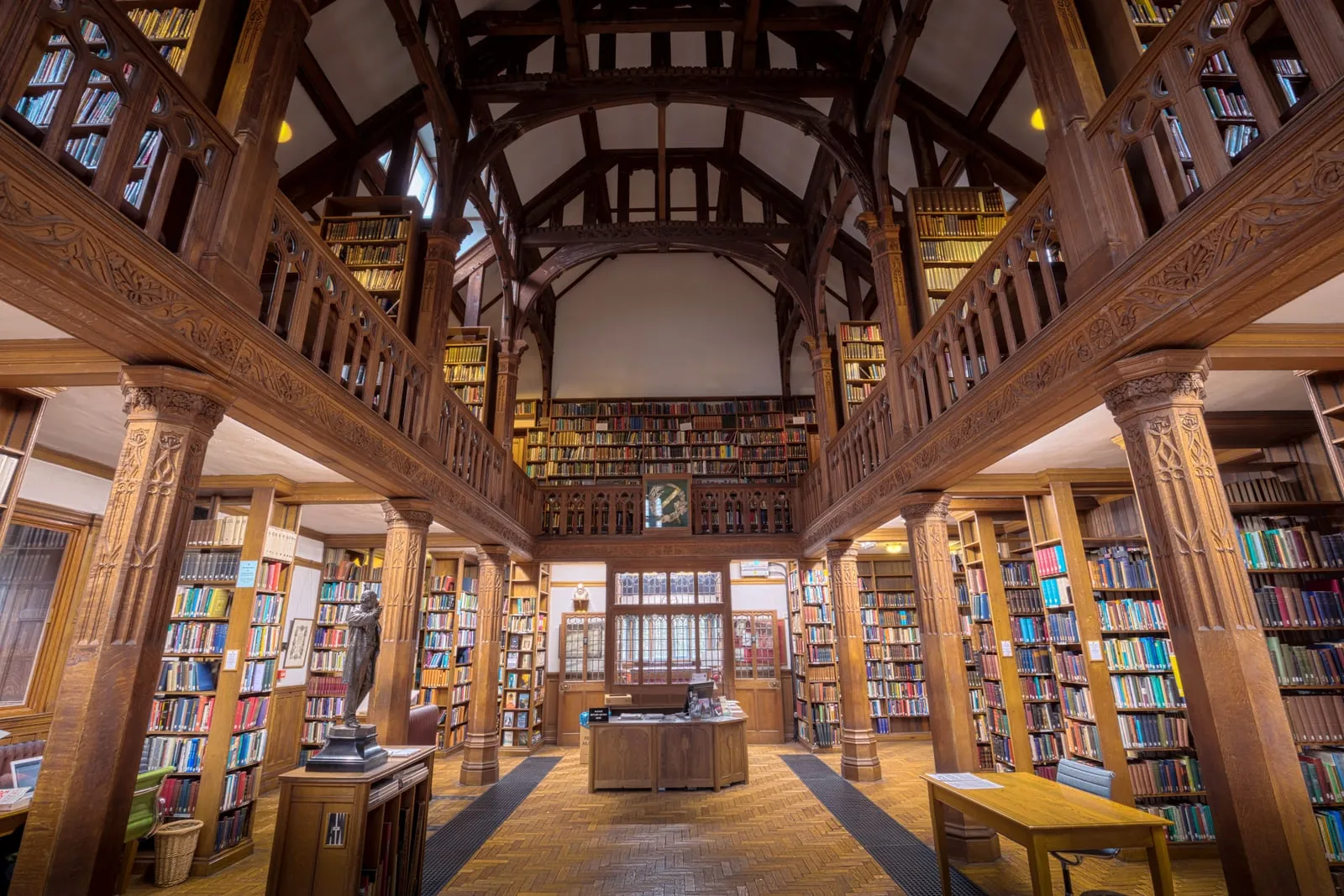 The interior of a wood-panelled library, with shelves of books on two levels