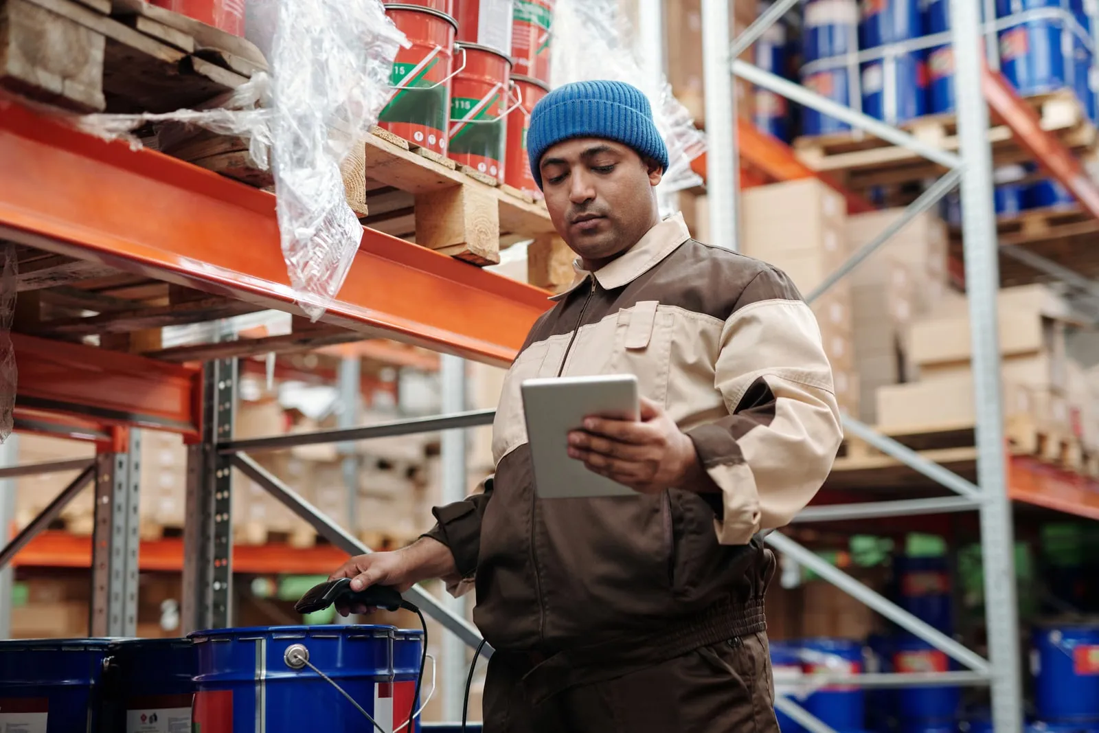 A warehouse worker scanning boxes on a shelf