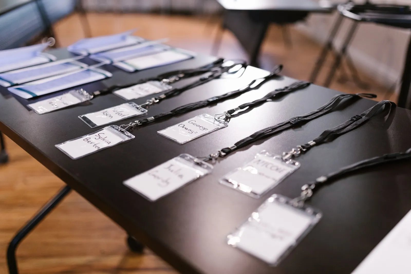 Name badges on lanyards laid out on a table