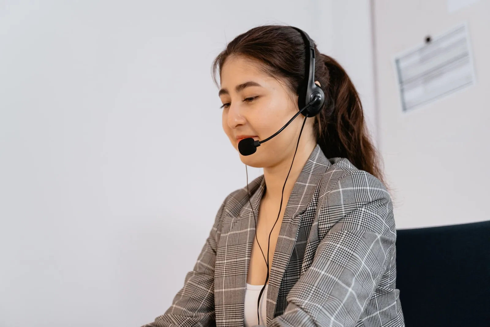A support worker wearing a headset at a desk