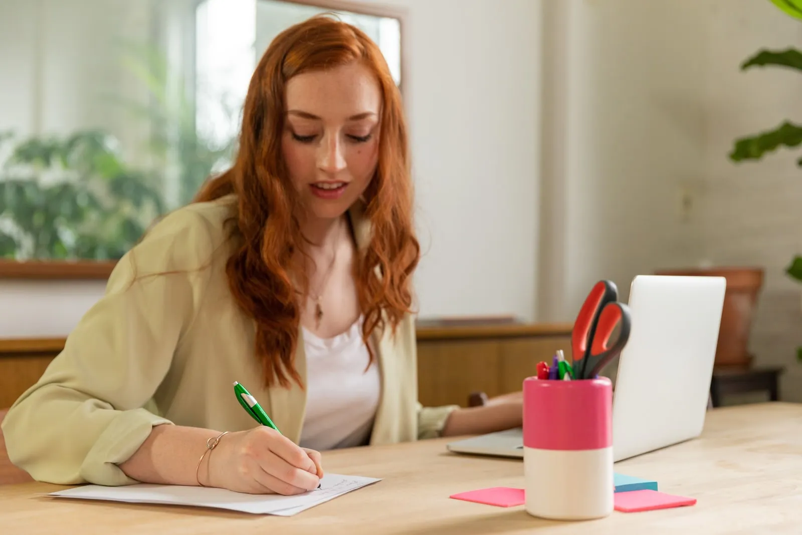 Une personne travaillant à un bureau avec un ordinateur portable et des papiers.