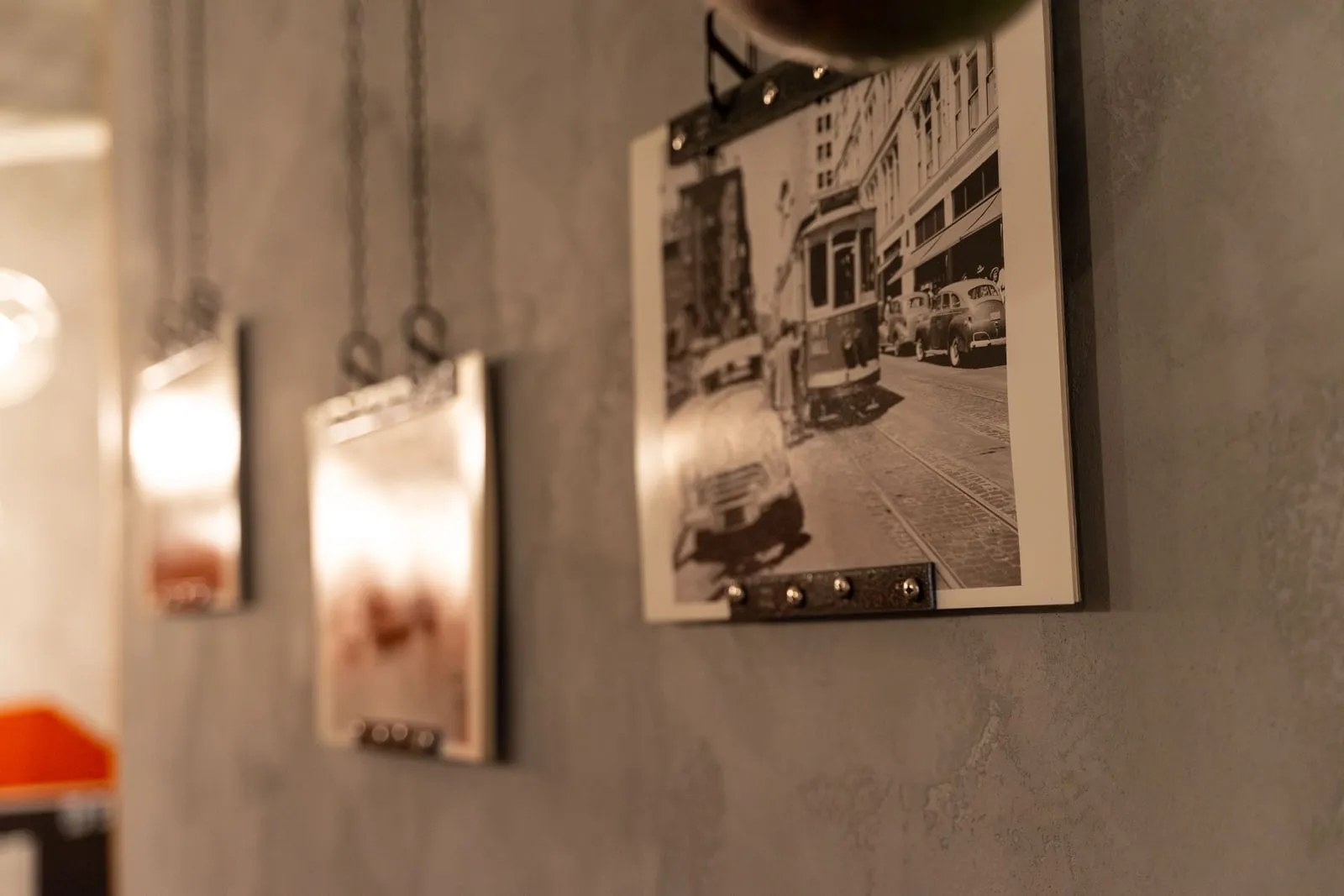 Clip-mounted black-and-white prints hanging on a concrete wall