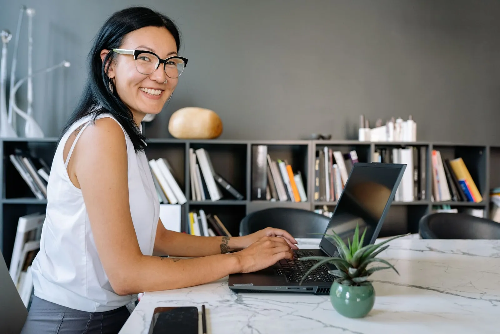 En person der arbejder ved en bærbar computer på et skrivebord