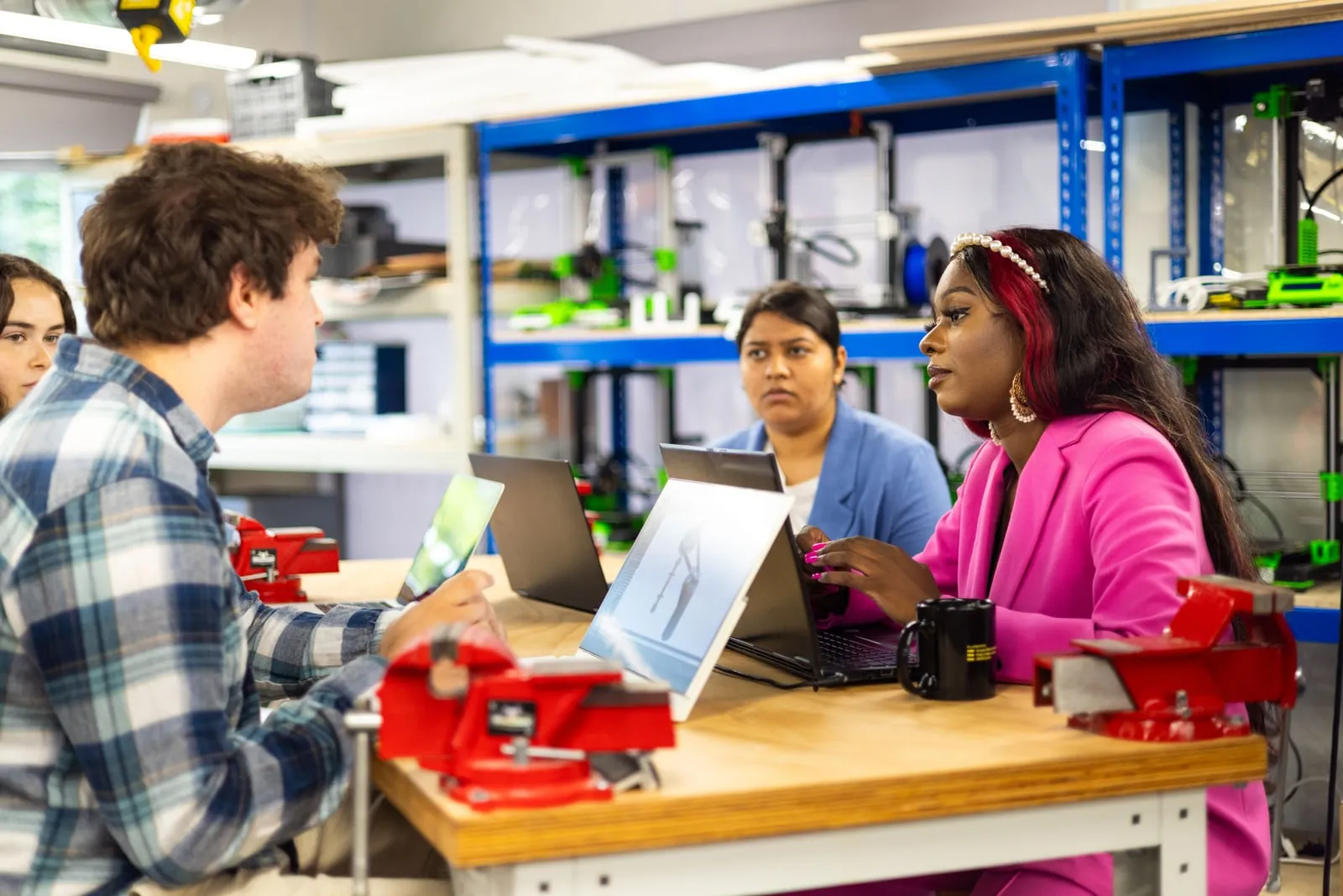 A team of engineers working together around a laptop