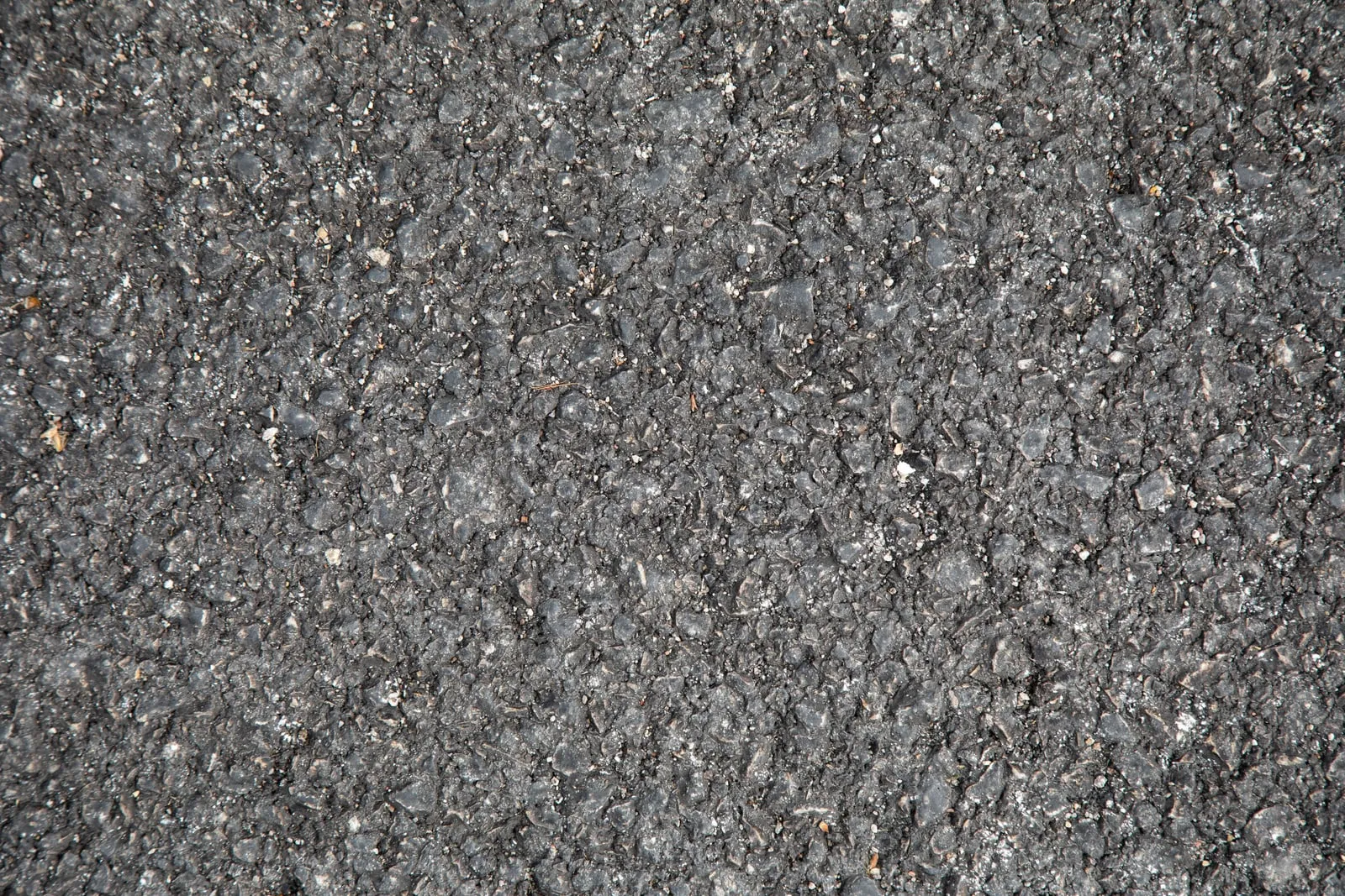 A close-up of a grey asphalt road surface