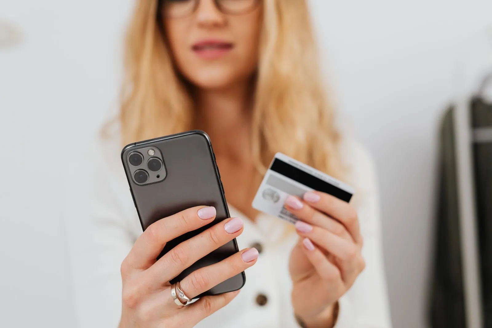 A person holding a credit card while using a phone