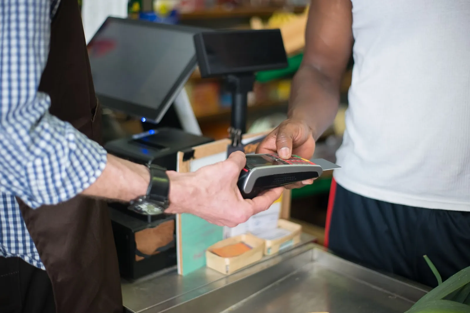 A customer paying by card at a shop counter